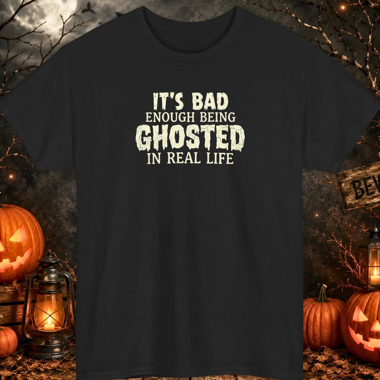 Funny Halloween graphic t-shirt featuring distressed ghost-inspired typography reading "It's Bad Enough Being Ghosted In Real Life" on a black shirt, perfect for Halloween parties, dating humor fans, ghost lovers, singles, and spooky season apparel.