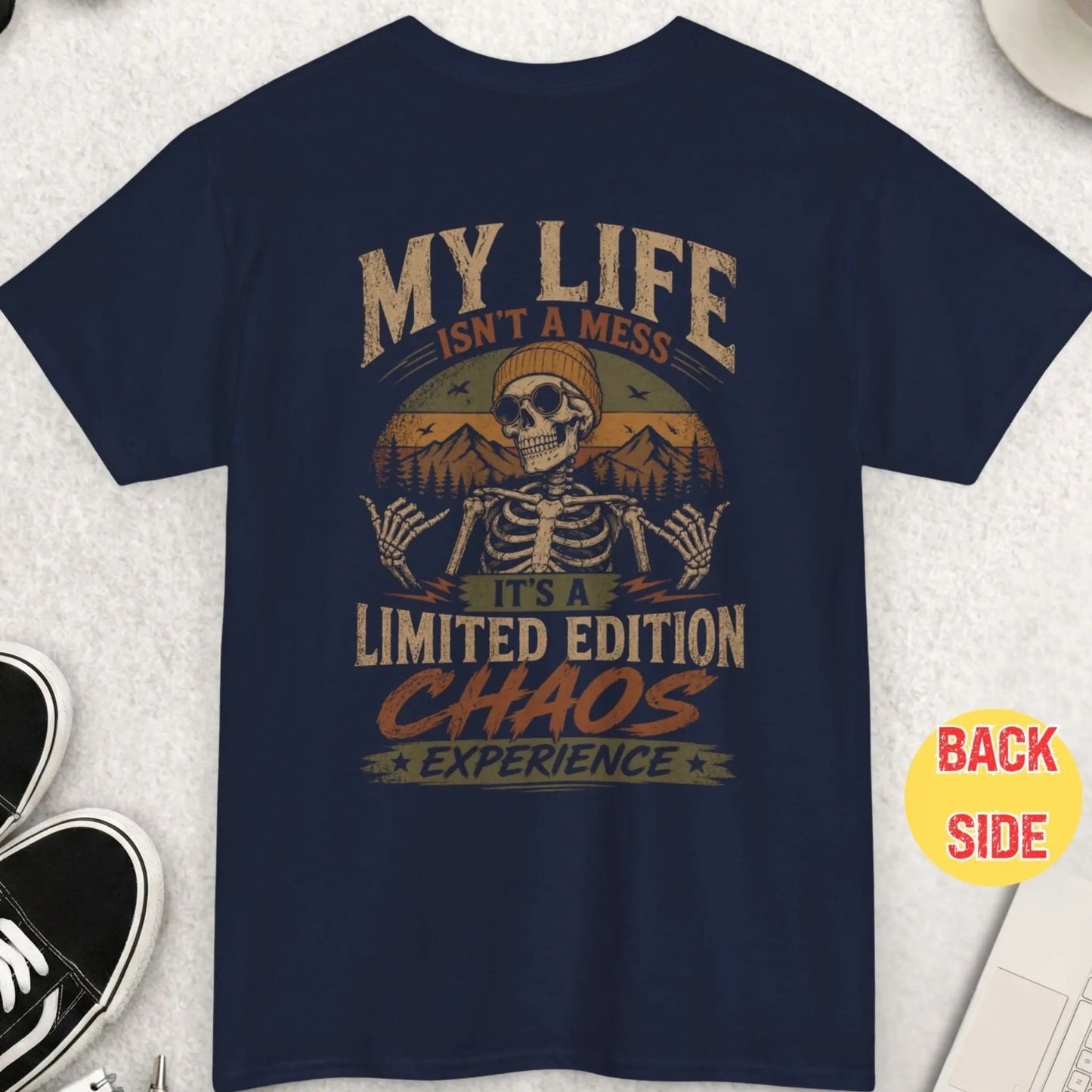 Navy blue t-shirt featuring cool skeleton graphic with retro mountains and humorous chaos quote about life being a limited edition experience