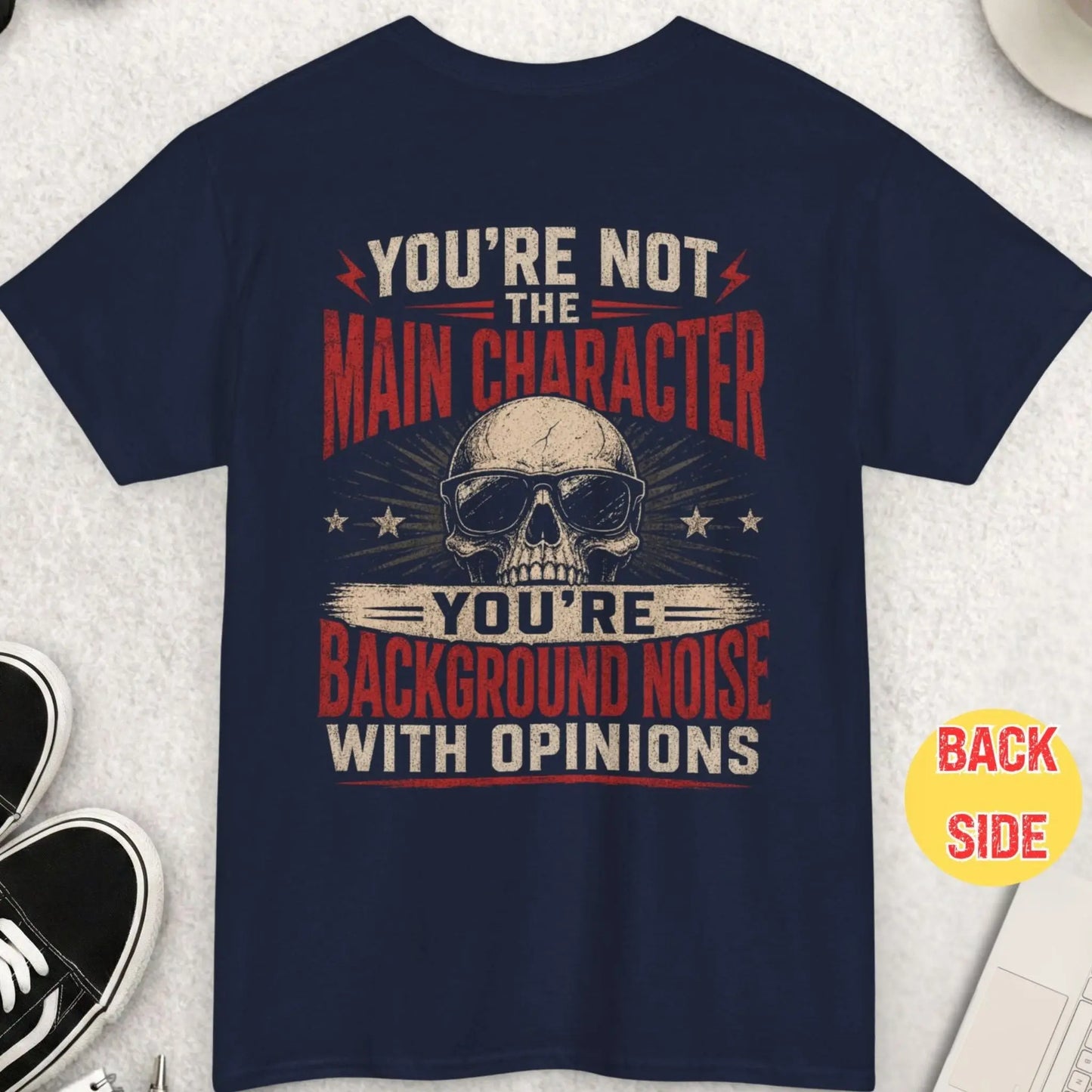 Navy blue t-shirt with vintage distressed text “You’re Not the Main Character You’re Background Noise With Opinions” and skull illustration