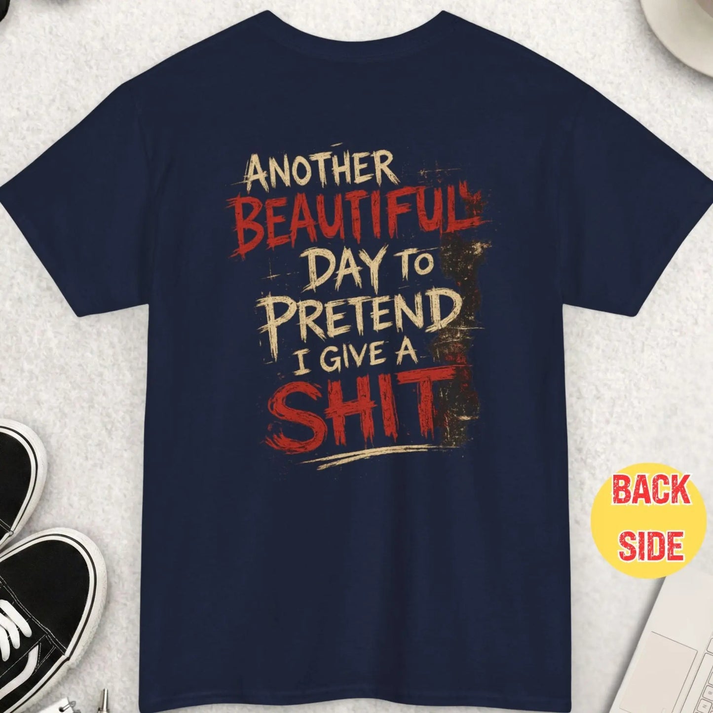 Navy blue sarcastic graphic tee with distressed cream and red handwritten typography reading “Another Beautiful Day To Pretend I Give A Shit” in an edgy alternative streetwear design by Mayhem Haus.