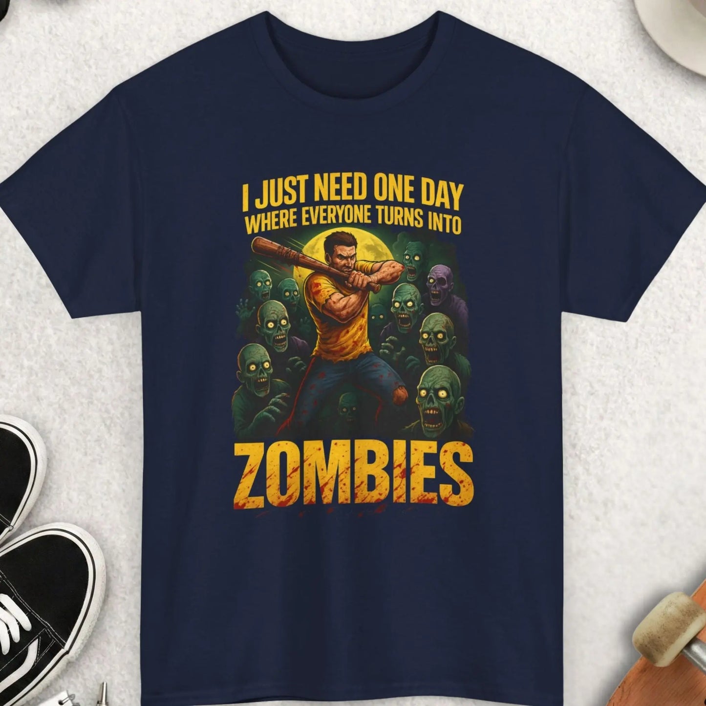 Navy blue t-shirt with graphic design and text on a light gray surface with accessories.
