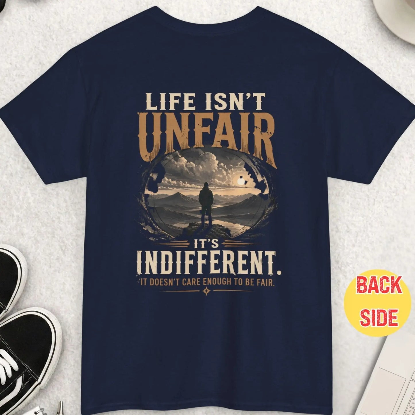 Navy blue t-shirt featuring philosophical quote about life being indifferent with scenic mountain view and solitary figure illustration