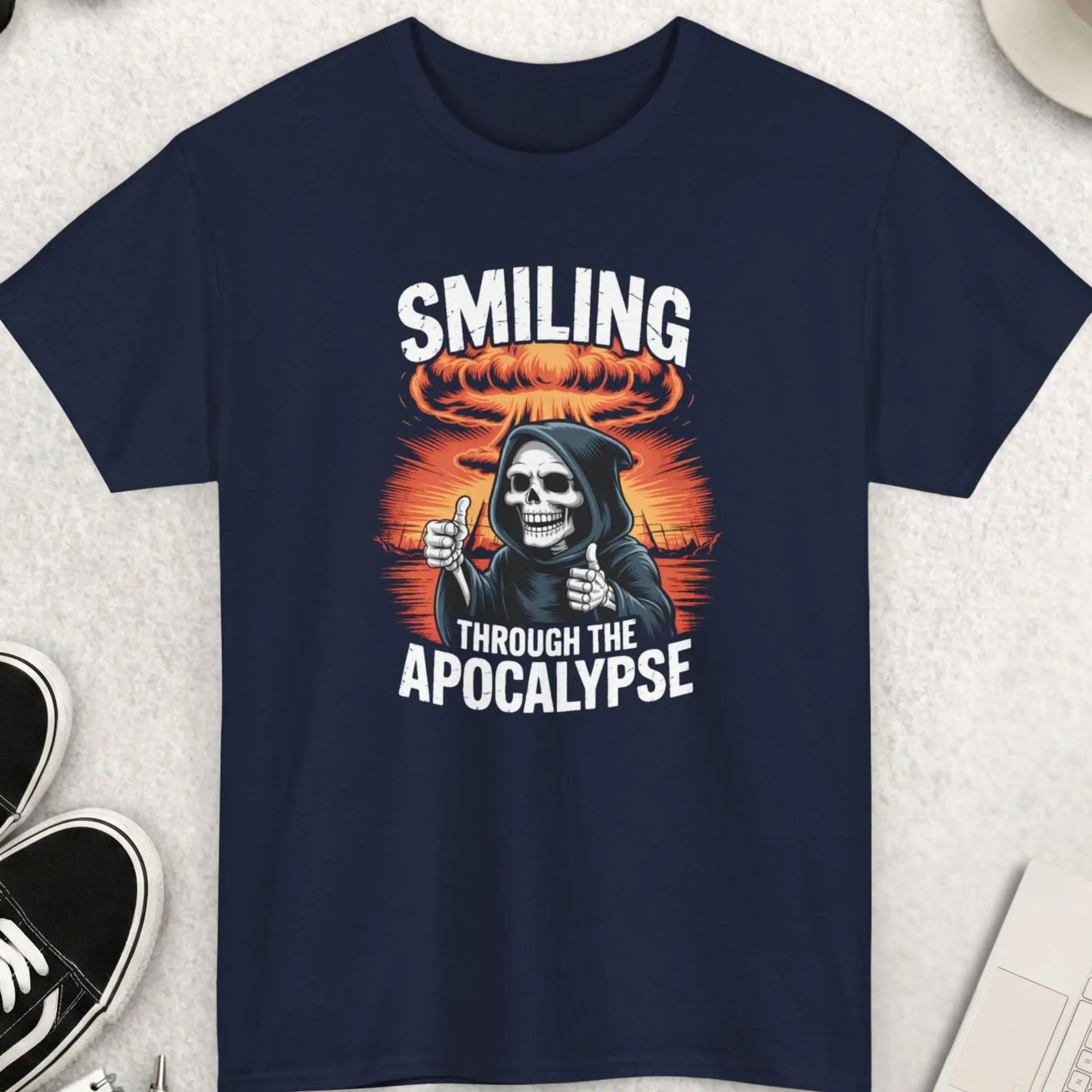 Navy blue t-shirt with graphic design and text on a light gray surface with accessories.