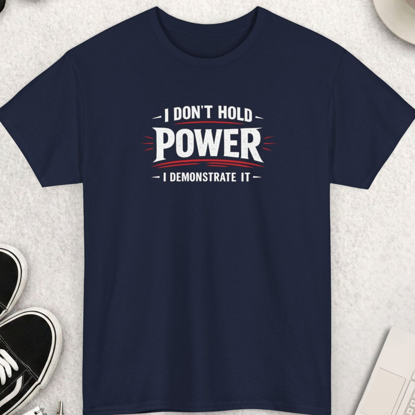 Navy blue t-shirt with motivational quote on a light gray surface with accessories.