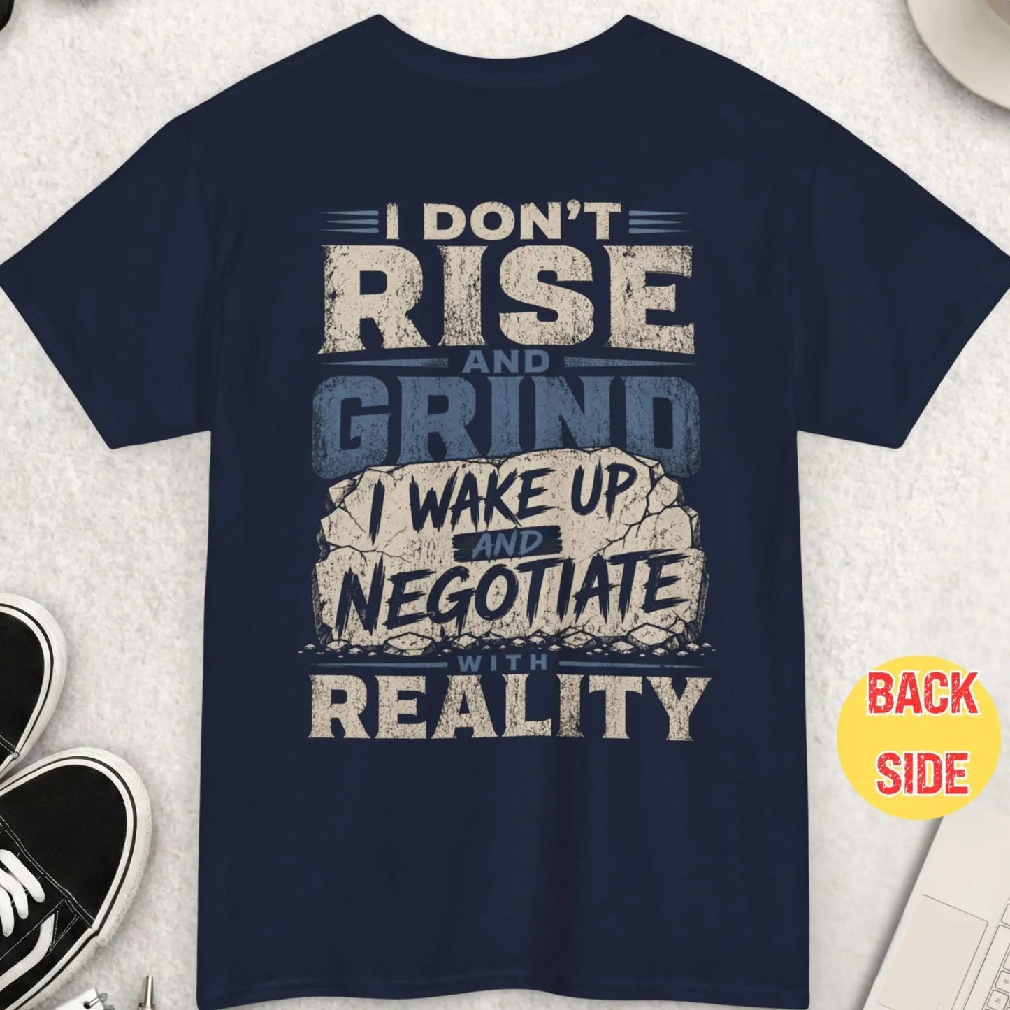 Navy blue t-shirt featuring bold distressed text about negotiating with reality instead of rising and grinding in a cracked typography design