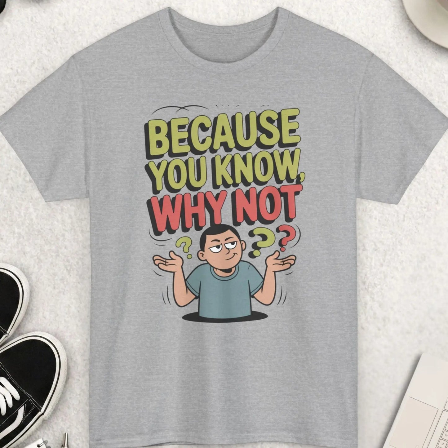 Gray t-shirt with a graphic design and text on a light gray surface with accessories.