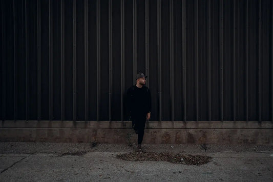 a man standing in front of a metal wall