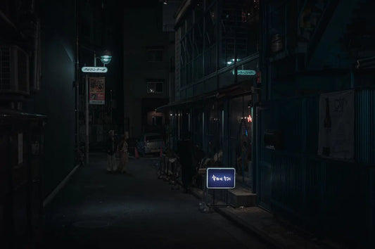 A dark alley with a computer monitor on the sidewalk