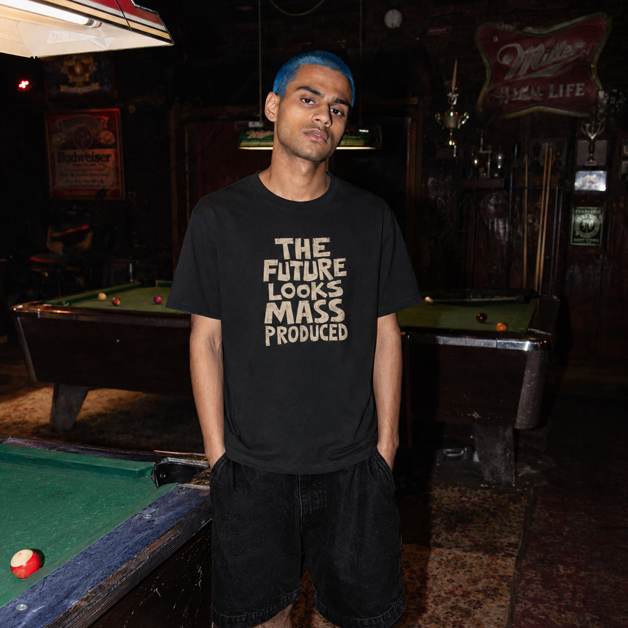 Mayhem Haus The Future Looks Mass Produced T-Shirt on a person with blue hair in a pool hall