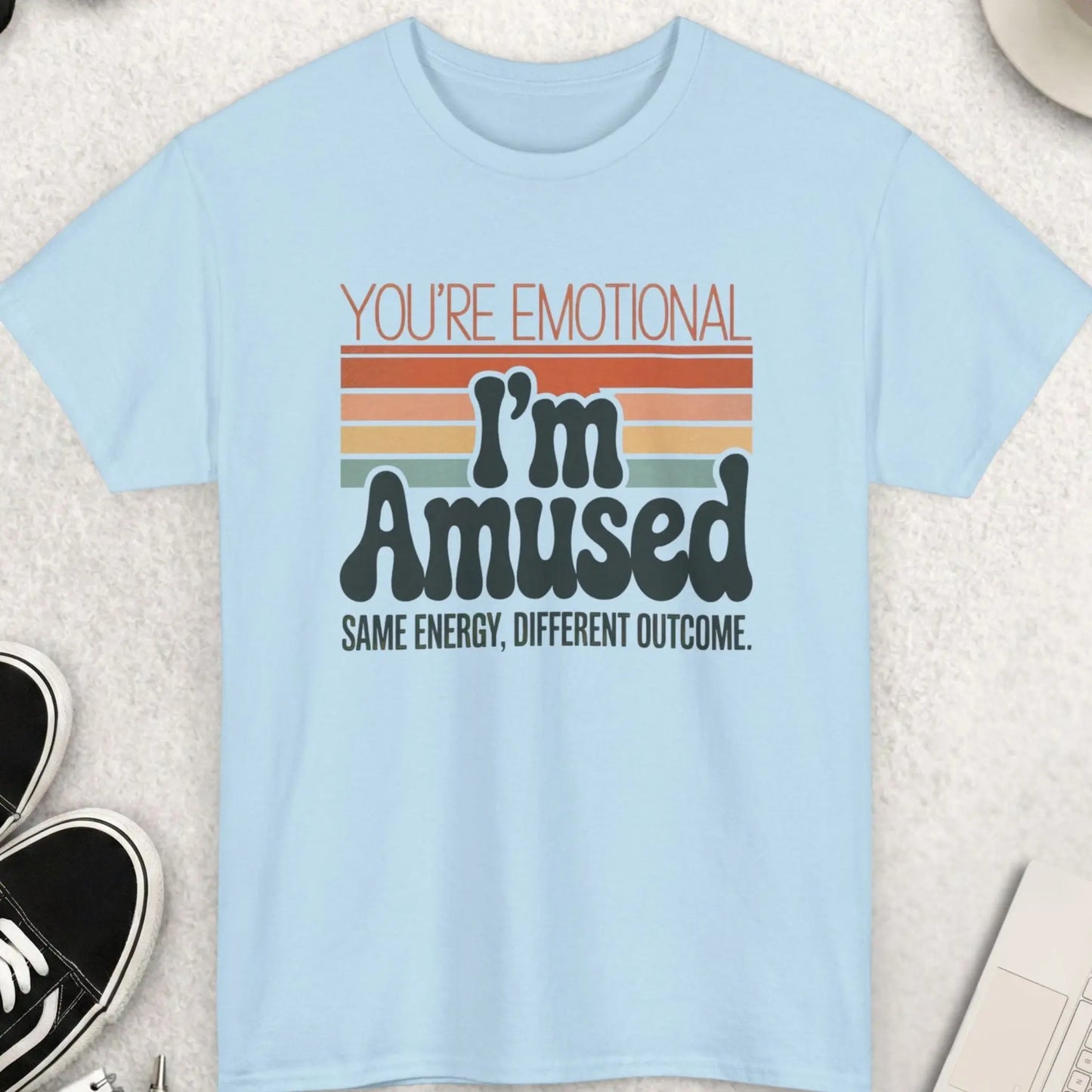 Light blue t-shirt with humorous text design on a light surface with accessories.