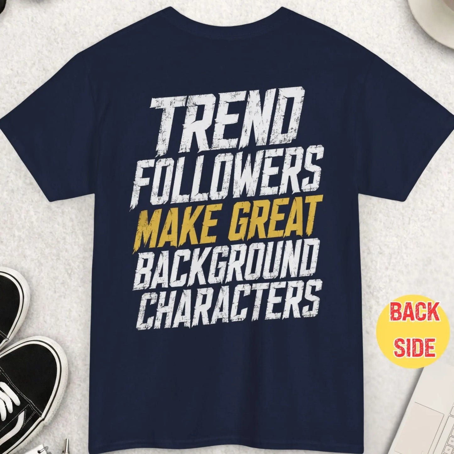 Navy blue sarcastic streetwear t-shirt featuring distressed white and gold lettering reading “Trend Followers Make Great Background Characters” in bold grunge-style typography.