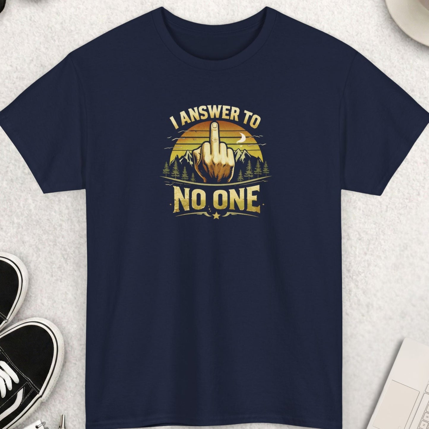 Navy blue t-shirt with graphic design and text on a light gray surface with accessories.