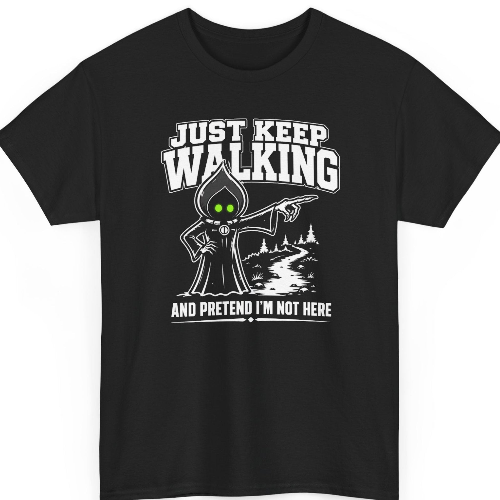Mayhem Haus Flatwoods Monster graphic t-shirt on a black shirt featuring a cartoon-style Flatwoods Monster with glowing neon green eyes pointing down a forest trail. Bold white typography reads "JUST KEEP WALKING" above and "AND PRETEND I'M NOT HERE" below in a clean, high-contrast cryptid design.