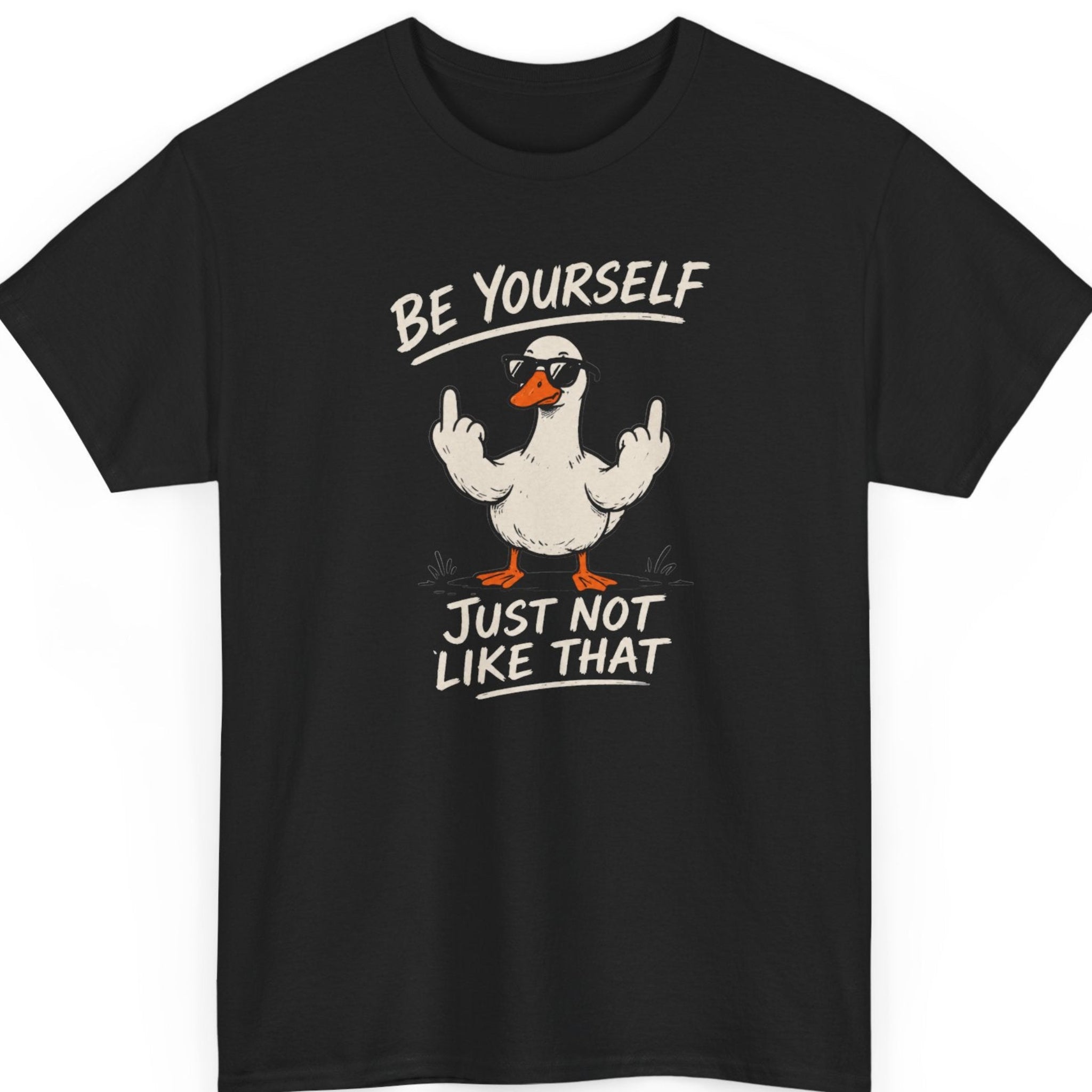 Mayhem Haus "Be Yourself Just Not Like That" graphic t-shirt on a black shirt featuring a funny duck wearing sunglasses and raising both middle fingers with distressed cream typography.