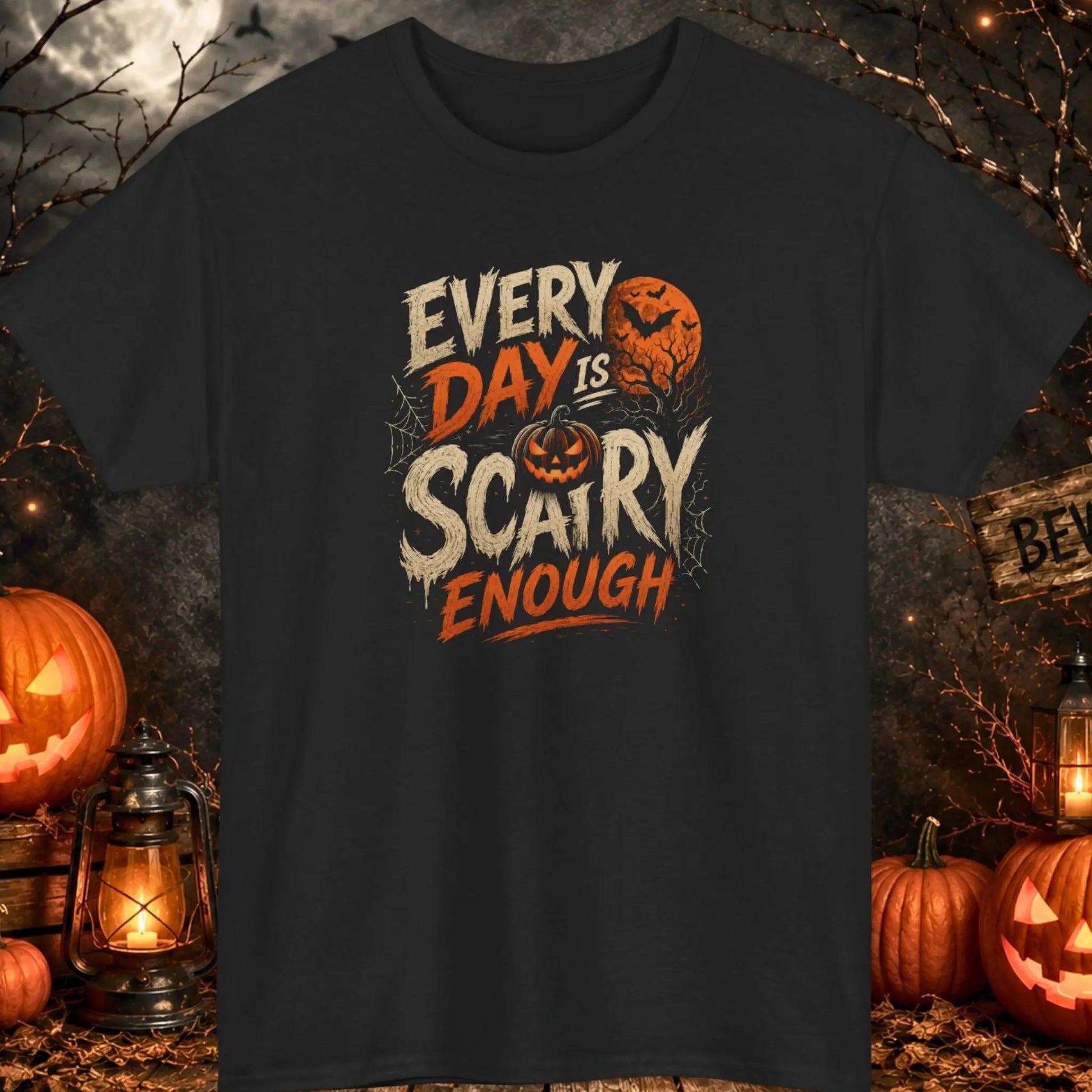 Funny Halloween graphic t-shirt featuring the phrase "Every Day Is Scary Enough" in distressed vintage typography with a jack-o'-lantern, bats, spider webs, haunted tree, and orange full moon on a black shirt, perfect for Halloween parties, spooky season, and dark humor lovers.