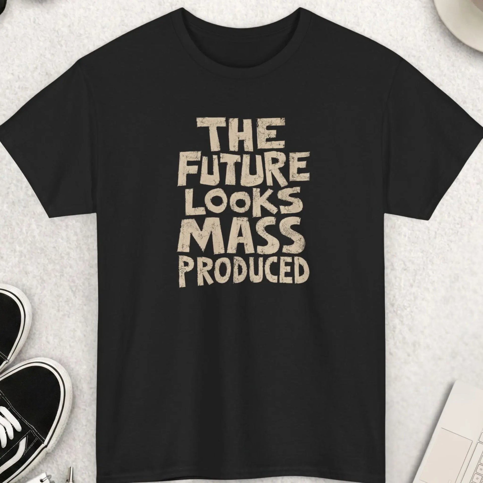 Distressed oversized typography t-shirt reading “The Future Looks Mass Produced” in vintage cream lettering on a black shirt with minimalist dark streetwear aesthetic.