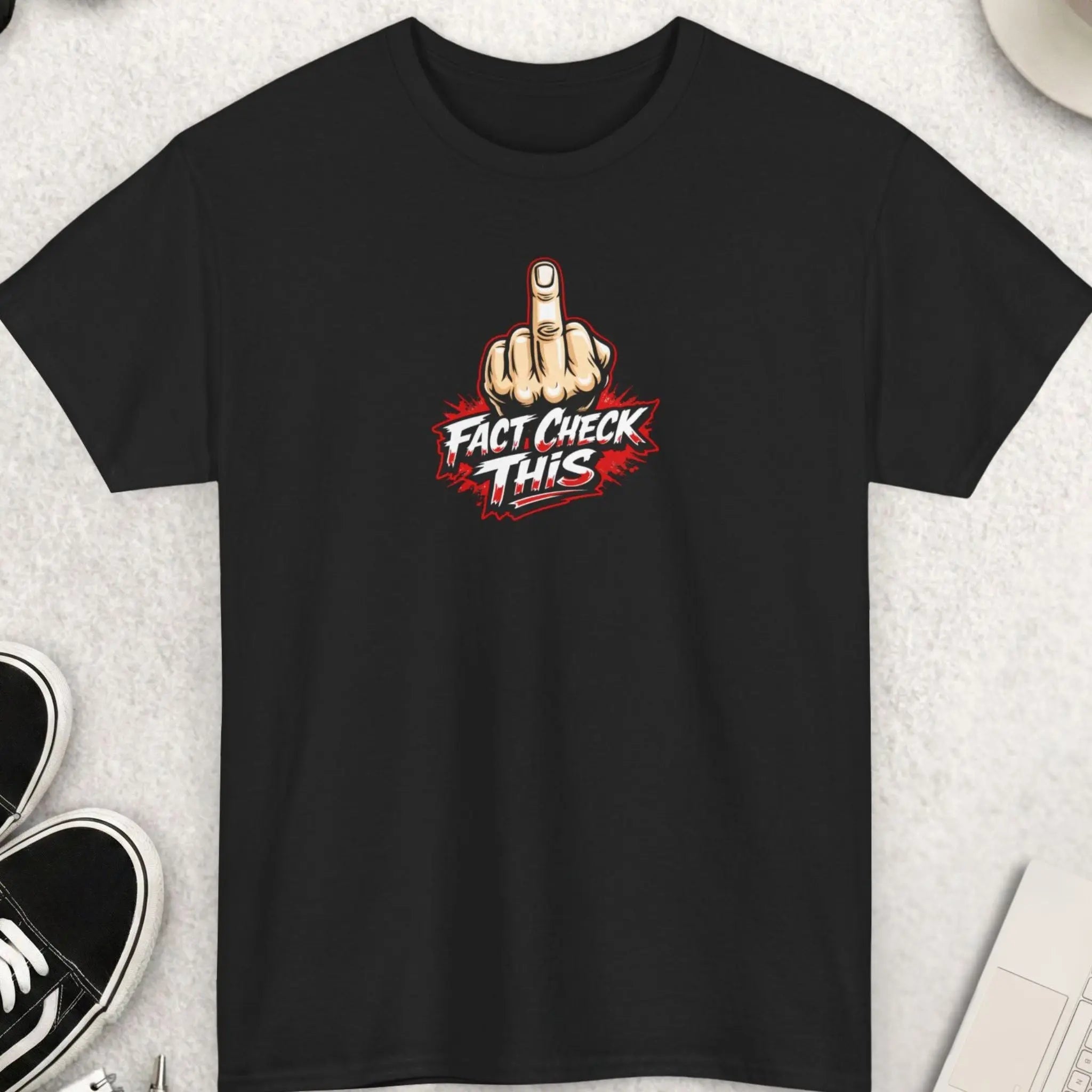 Black t-shirt with 'FACT CHECK THIS' text on a black surface with accessories.