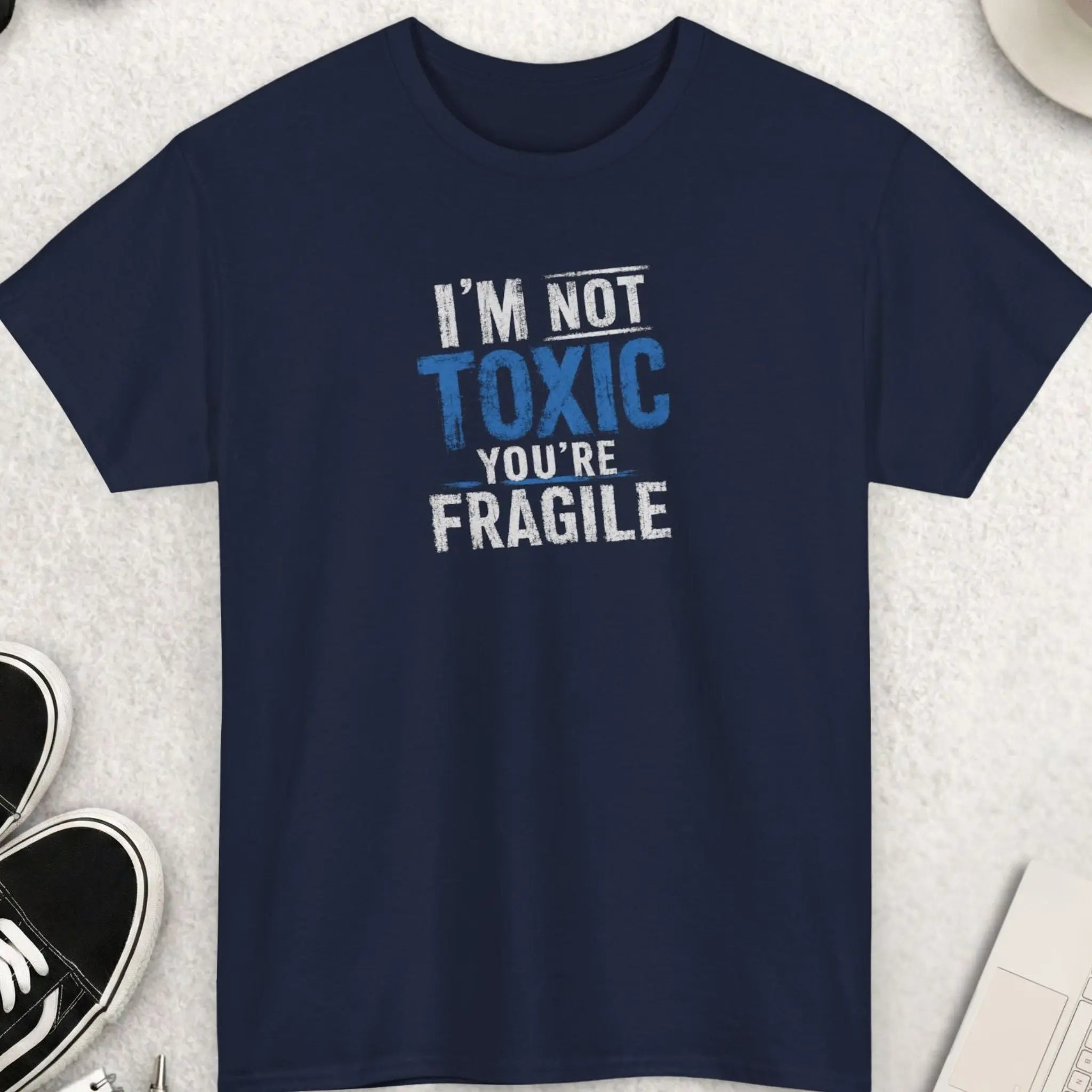 Navy blue graphic tee displaying distressed oversized blue and white typography with the phrase “I’m Not Toxic, You’re Fragile” in a rebellious vintage streetwear style.