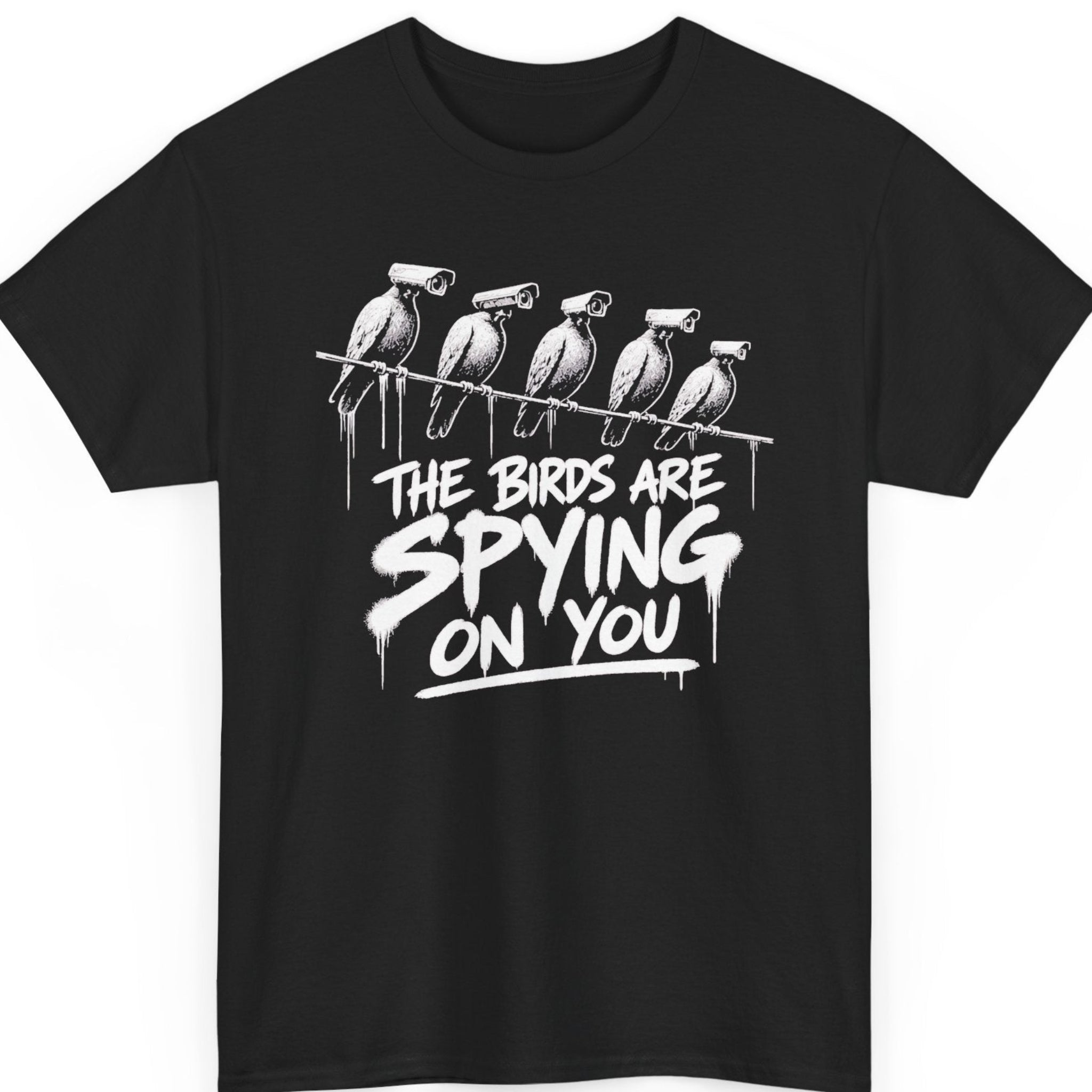 Mayhem Haus conspiracy humor t-shirt on a black shirt featuring five birds perched on a wire with surveillance cameras replacing their heads above the phrase, “The Birds Are Spying On You,” in distressed white graffiti-style lettering.