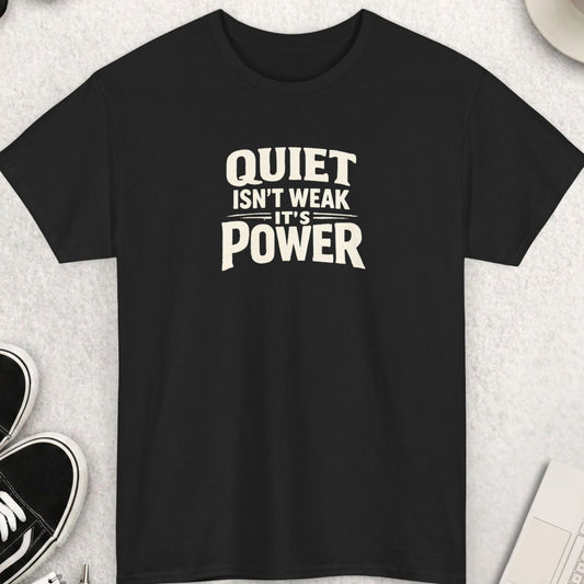 Black t-shirt with 'QUIET ISN'T WEAK IT'S POWER' text on a light gray surface with shoes, coffee, and accessories.