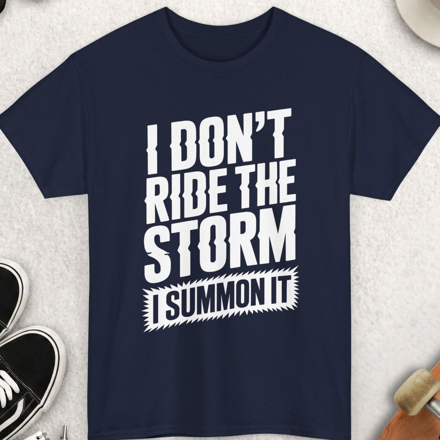 Navy blue t-shirt with white text on a light gray surface with accessories around.