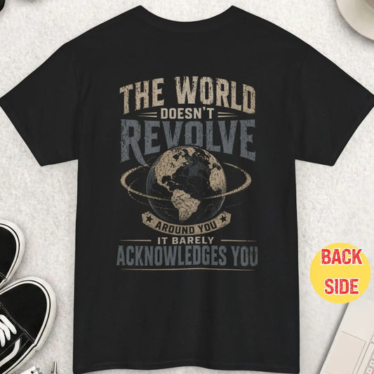 Black t-shirt featuring distressed vintage typography reading “The World Doesn’t Revolve Around You It Barely Acknowledges You” with a detailed globe graphic in the center and bold high-contrast print.