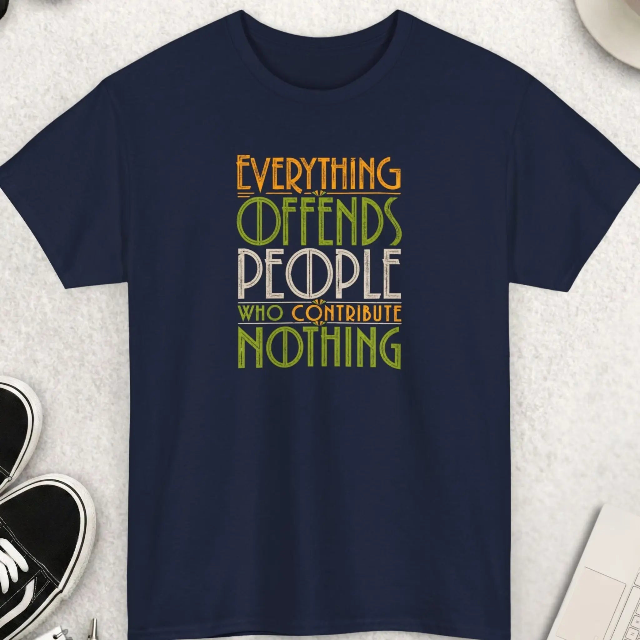 Navy blue sarcastic graphic tee featuring distressed retro typography reading “Everything Offends People Who Contribute Nothing” in green, cream, and gold vintage-style lettering.