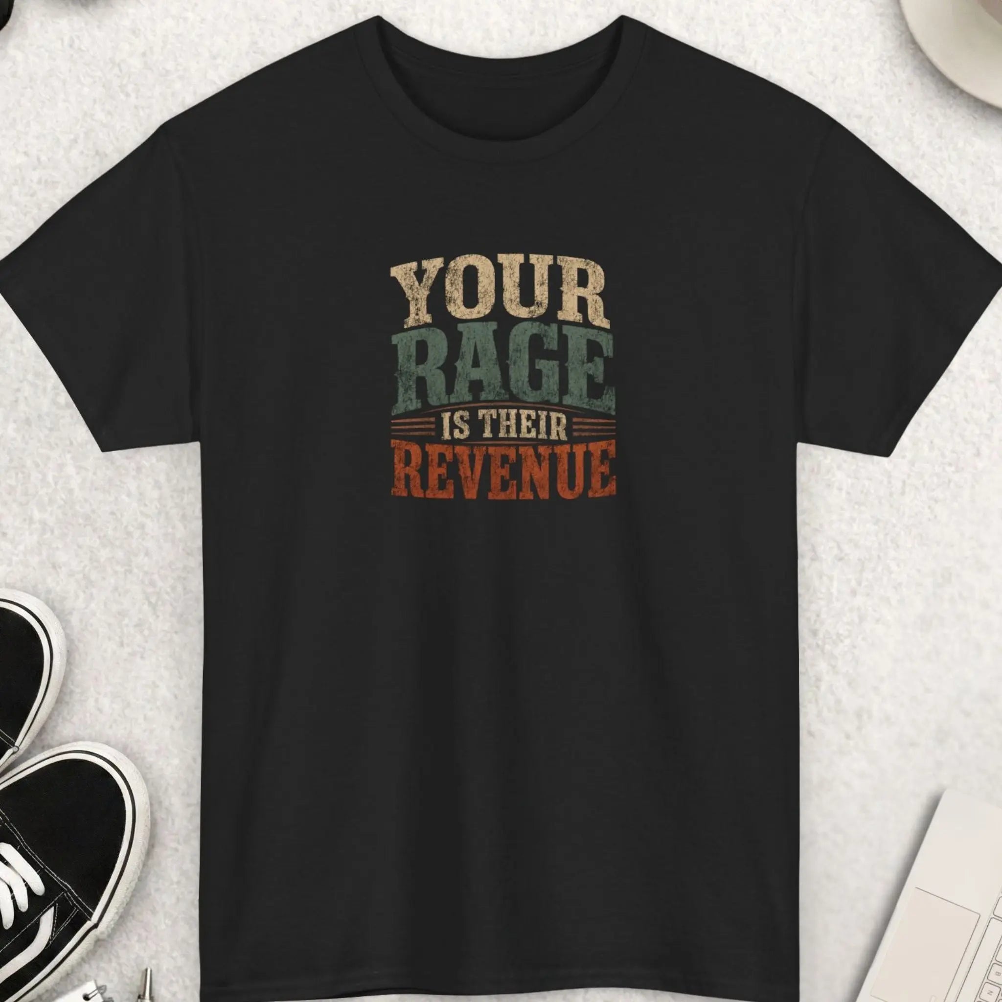 Your Rage Is Their Revenue" vintage distressed typography graphic t-shirt on a black background. Bold stacked lettering in warm cream, sage olive green, and burnt rust orange with a grunge texture finish. Anti-media outrage culture sarcastic statement tee.