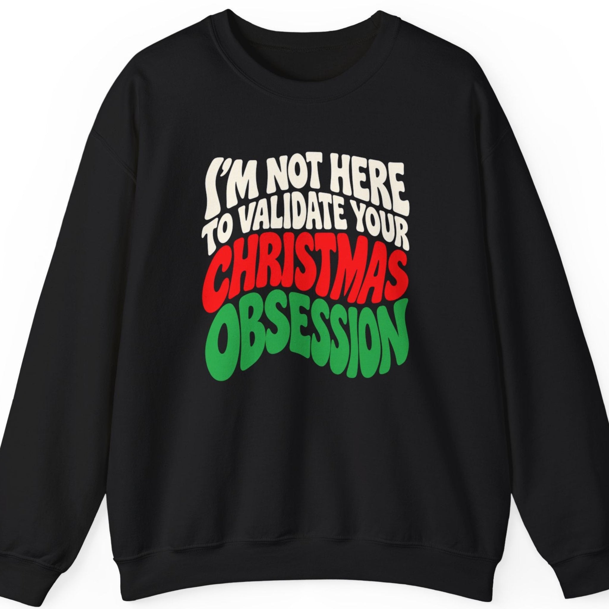 Mayhem Haus “I'm Not Here to Validate Your Christmas Obsession” black crewneck sweatshirt featuring oversized cream white, red, and green retro-style typography in a bold stacked layout. The typography-only design delivers a sarcastic Christmas statement with playful vintage-inspired lettering.