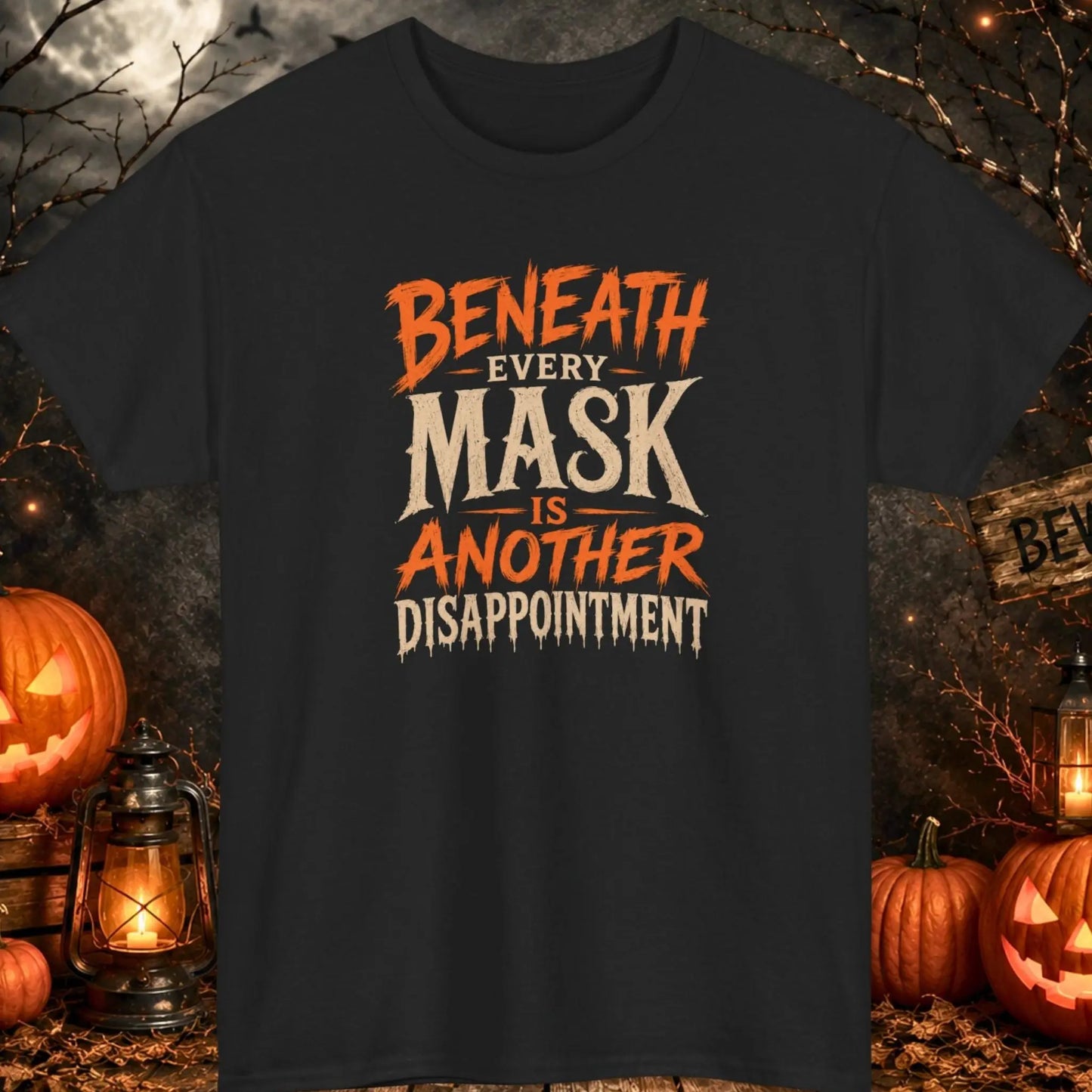 Funny Halloween graphic t-shirt featuring distressed vintage horror typography that reads "Beneath Every Mask Is Another Disappointment" on a black shirt, perfect for dark humor fans, sarcastic personalities, Halloween parties, and spooky season apparel.
