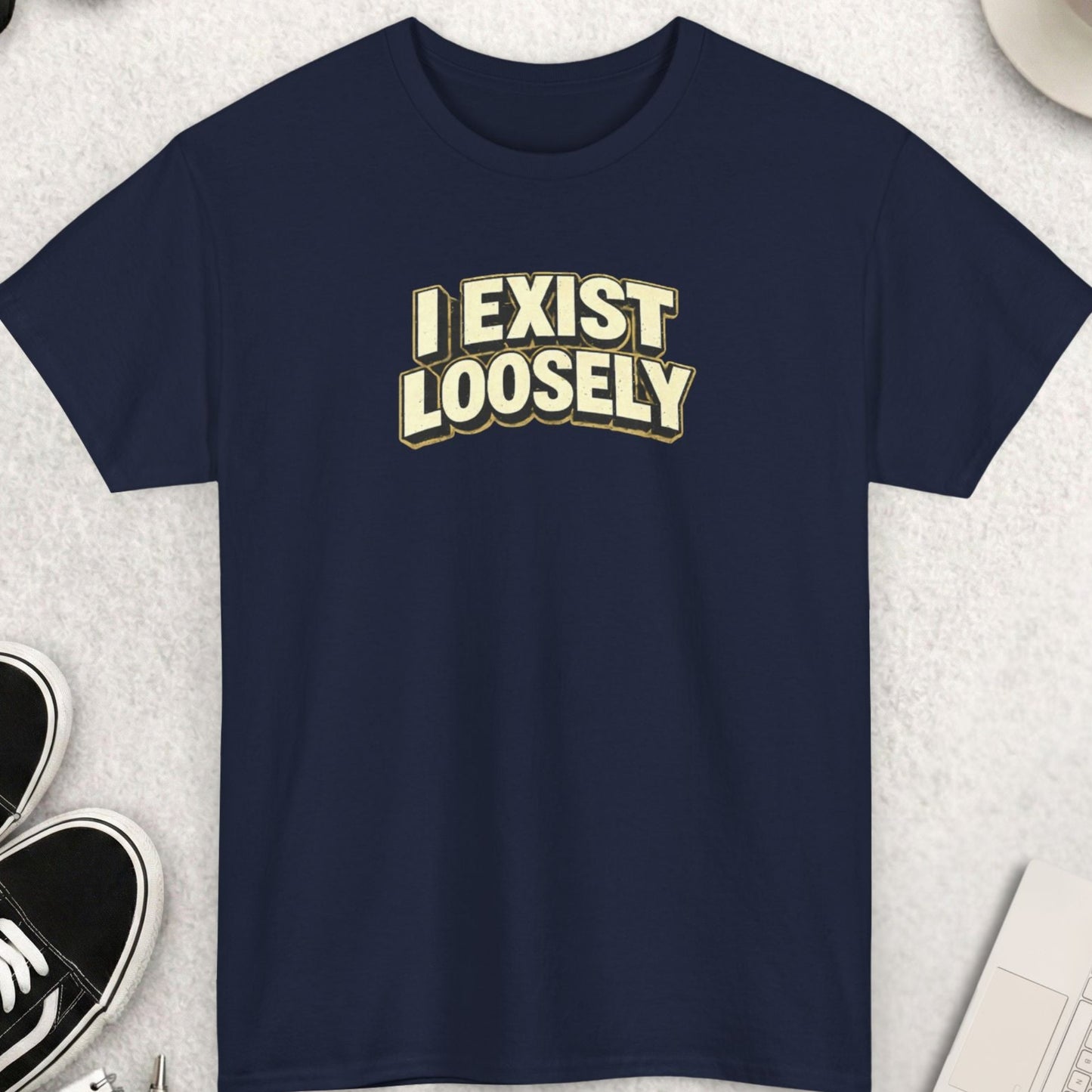 Navy blue t-shirt with 'I EXIST LOOSELY' text on a light gray surface with accessories.