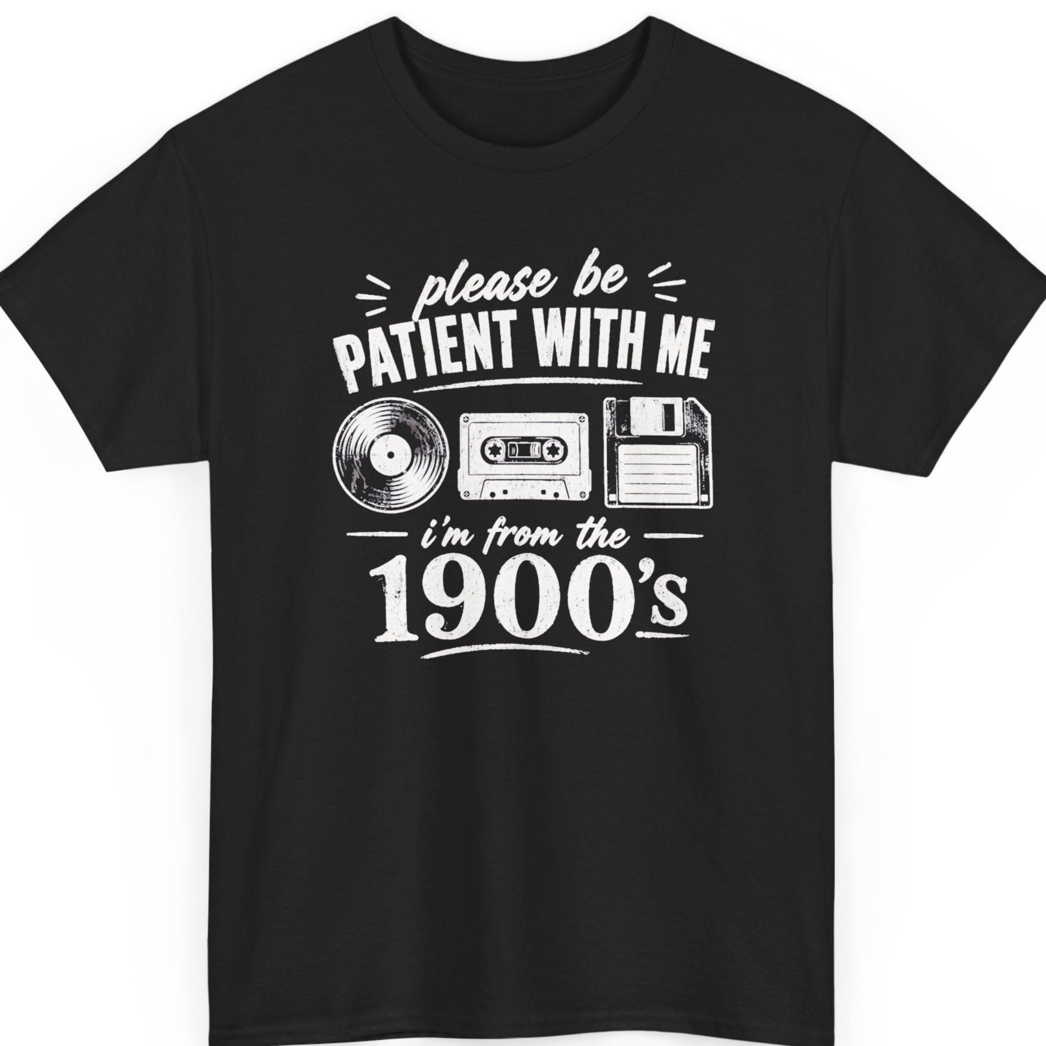 Mayhem Haus vintage humor t-shirt on a black shirt featuring distressed white typography, a vinyl record, cassette tape, and floppy disk surrounding the phrase, “Please Be Patient With Me, I'm From the 1900's.”