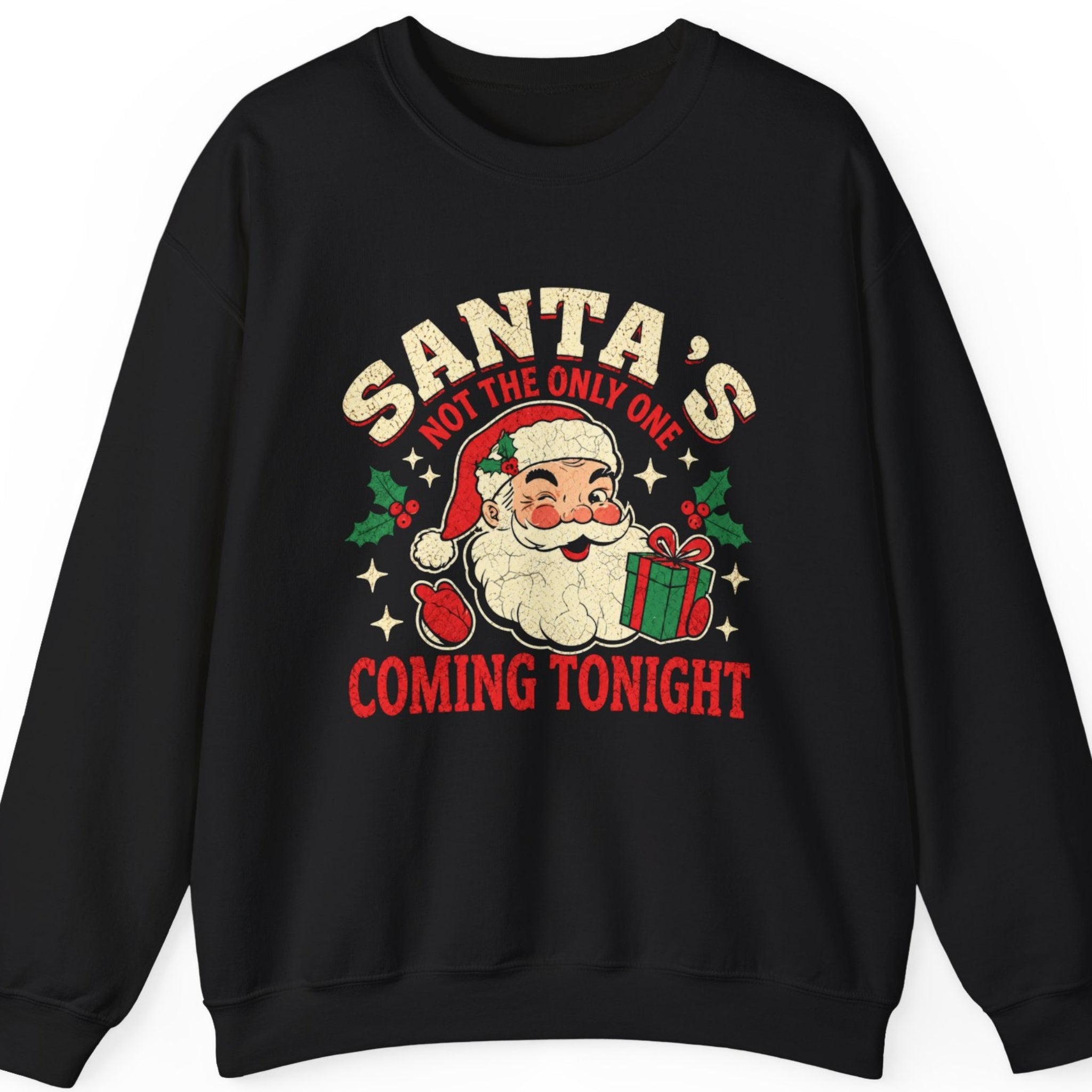 Mayhem Haus “Santa's Not the Only One Coming Tonight” black sweatshirt featuring a cheerful retro Santa Claus holding a wrapped Christmas gift, surrounded by distressed cream and red typography, festive holly, berries, and stars. A vintage-inspired Christmas graphic with a playful double entendre.