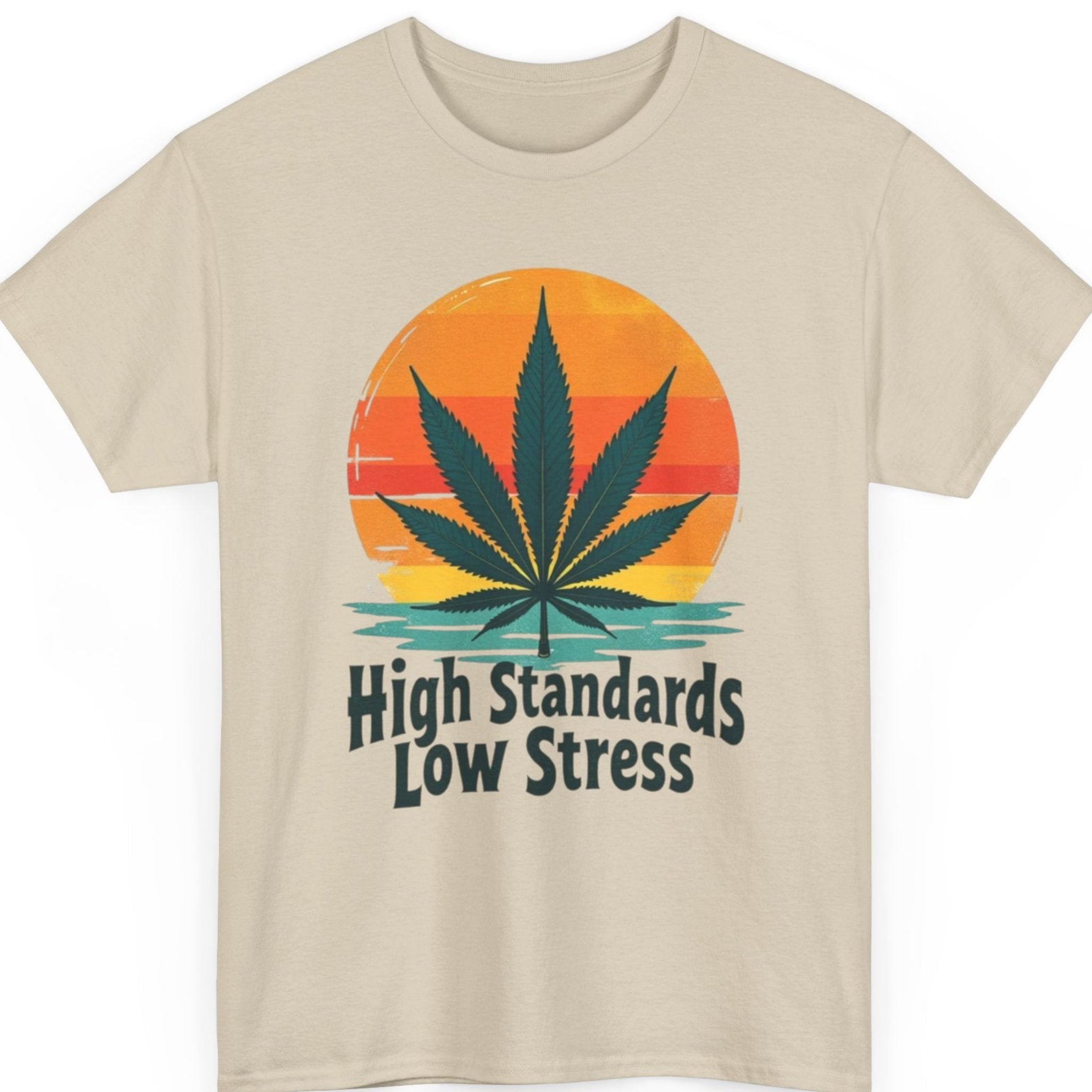Mayhem Haus retro cannabis t-shirt on a sand shirt featuring a colorful sunset, dark green marijuana leaf, and vintage typography that reads "High Standards Low Stress."