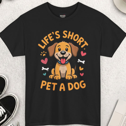Black t-shirt with a dog graphic and text on a light gray surface with accessories.