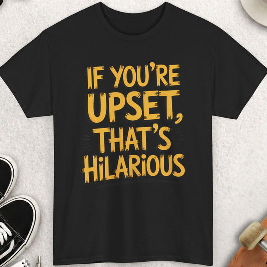 Black t-shirt with yellow text 'IF YOU'RE UPSET, THAT'S HILARIOUS' on a light gray surface with accessories.