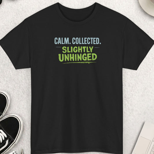 Black t-shirt with text 'CALM. COLLECTED. SLIGHTLY UNHINGED' on a light gray surface with shoes, coffee, and accessories.