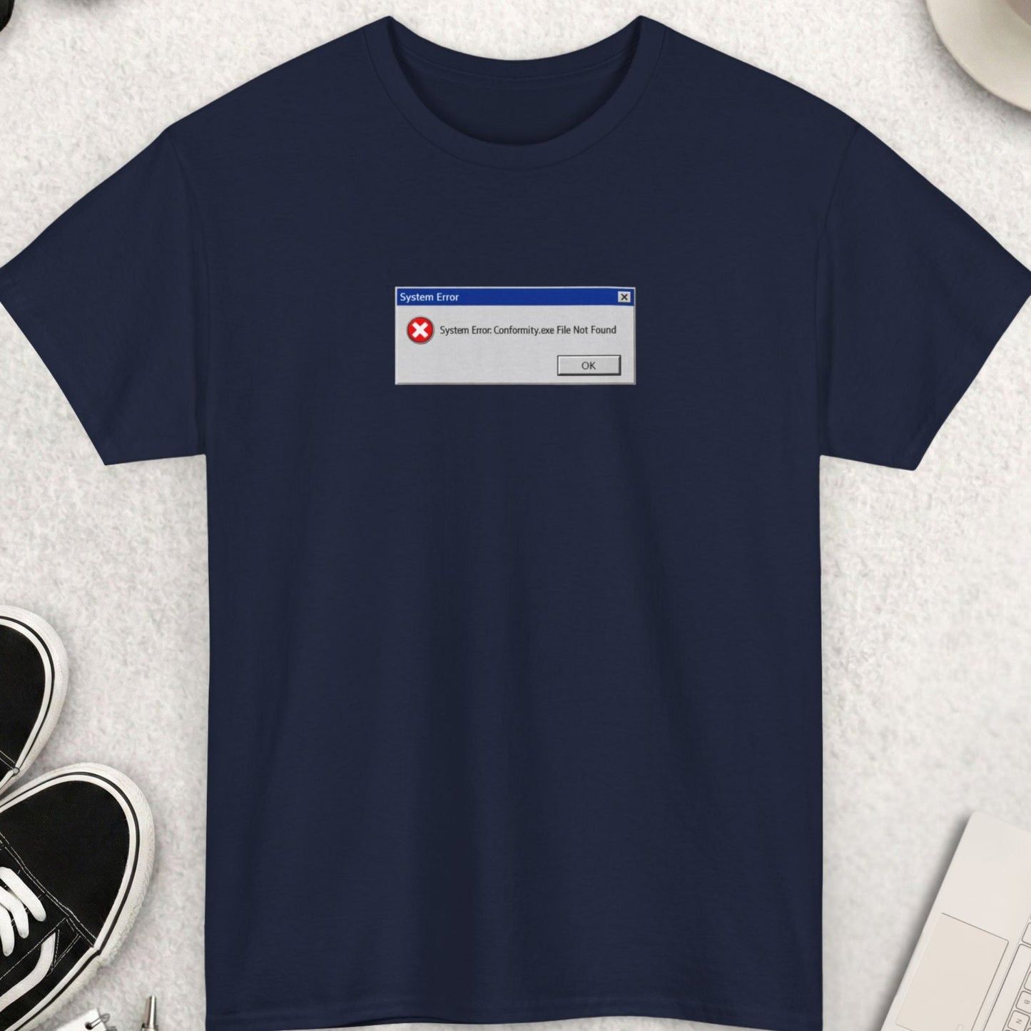 Navy blue t-shirt with a graphic on a light gray surface with accessories.