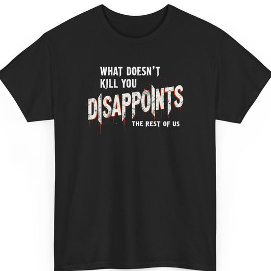Mayhem Haus sarcastic typography t-shirt on a black shirt featuring the phrase "What Doesn't Kill You Disappoints The Rest Of Us" in distressed white industrial lettering, with "DISAPPOINTS" enlarged and accented by red paint drips for a gritty streetwear aesthetic.