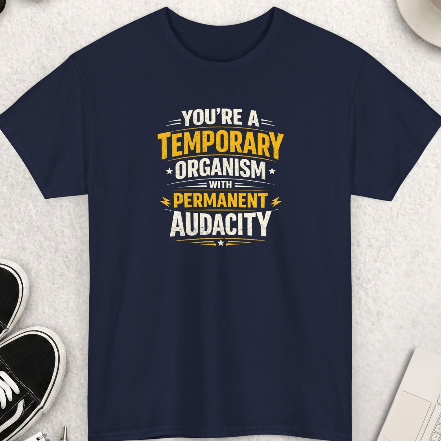 Navy blue t-shirt with motivational quote on a light gray surface with accessories.
