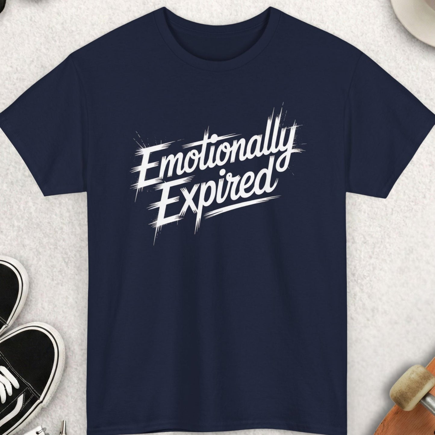 Navy blue t-shirt with 'Emotionally Expired' text on a light gray surface with accessories.