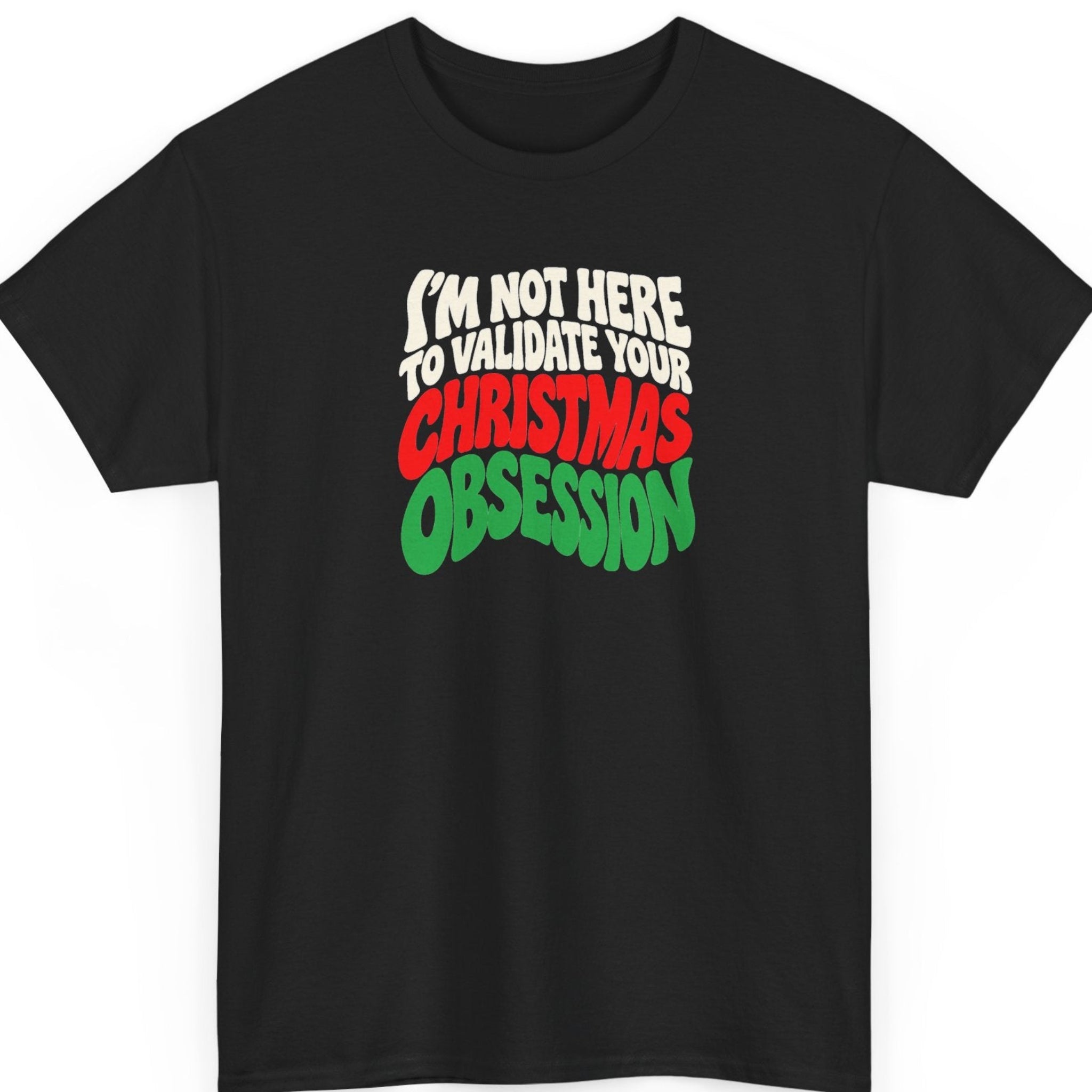 Mayhem Haus “I'm Not Here to Validate Your Christmas Obsession” black t-shirt featuring bold, stacked, retro-inspired typography in cream white, bright red, and green, with a slightly warped, playful lettering style and a clean, typography-only Christmas design.