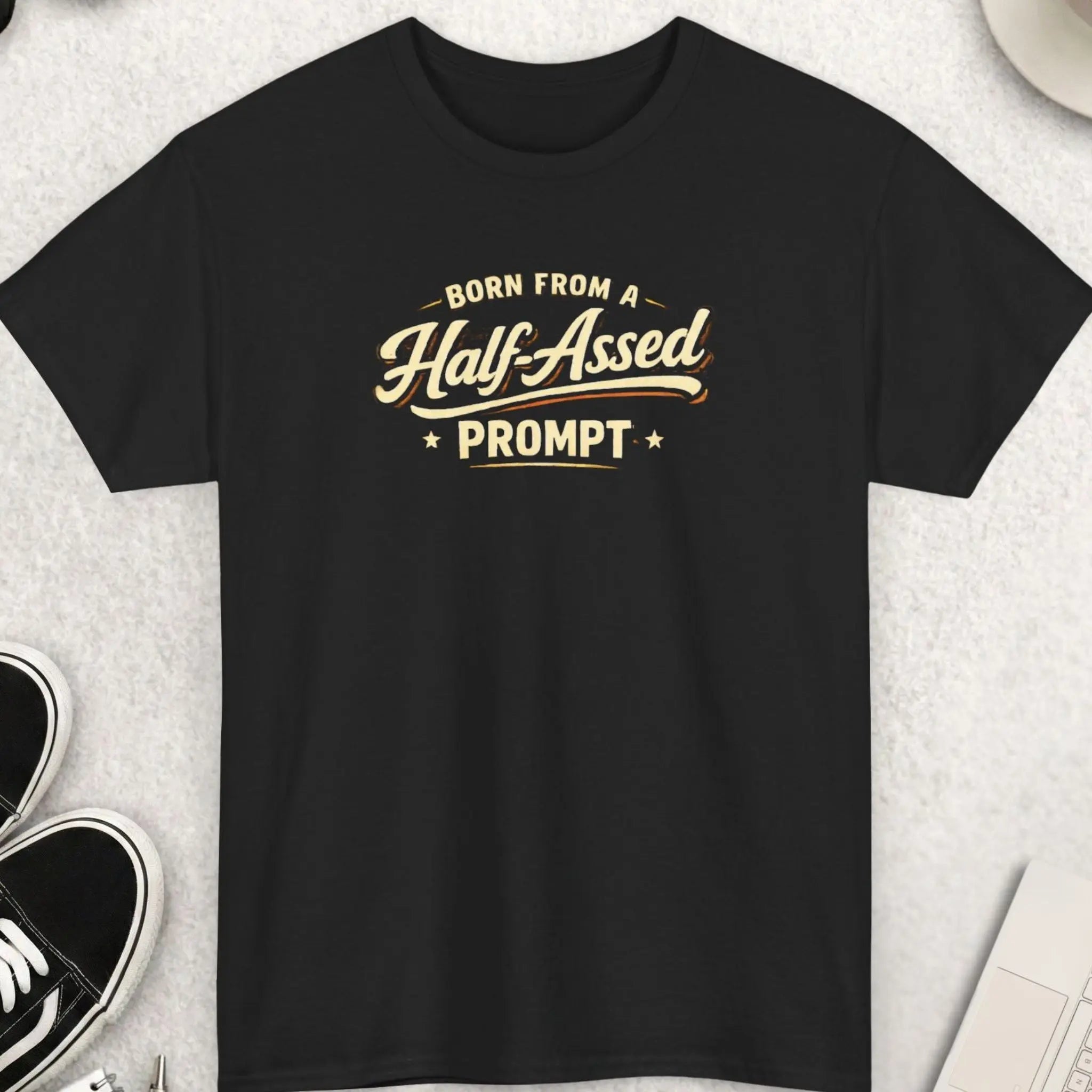 Black t-shirt with humorous text on a light gray surface with accessories.
