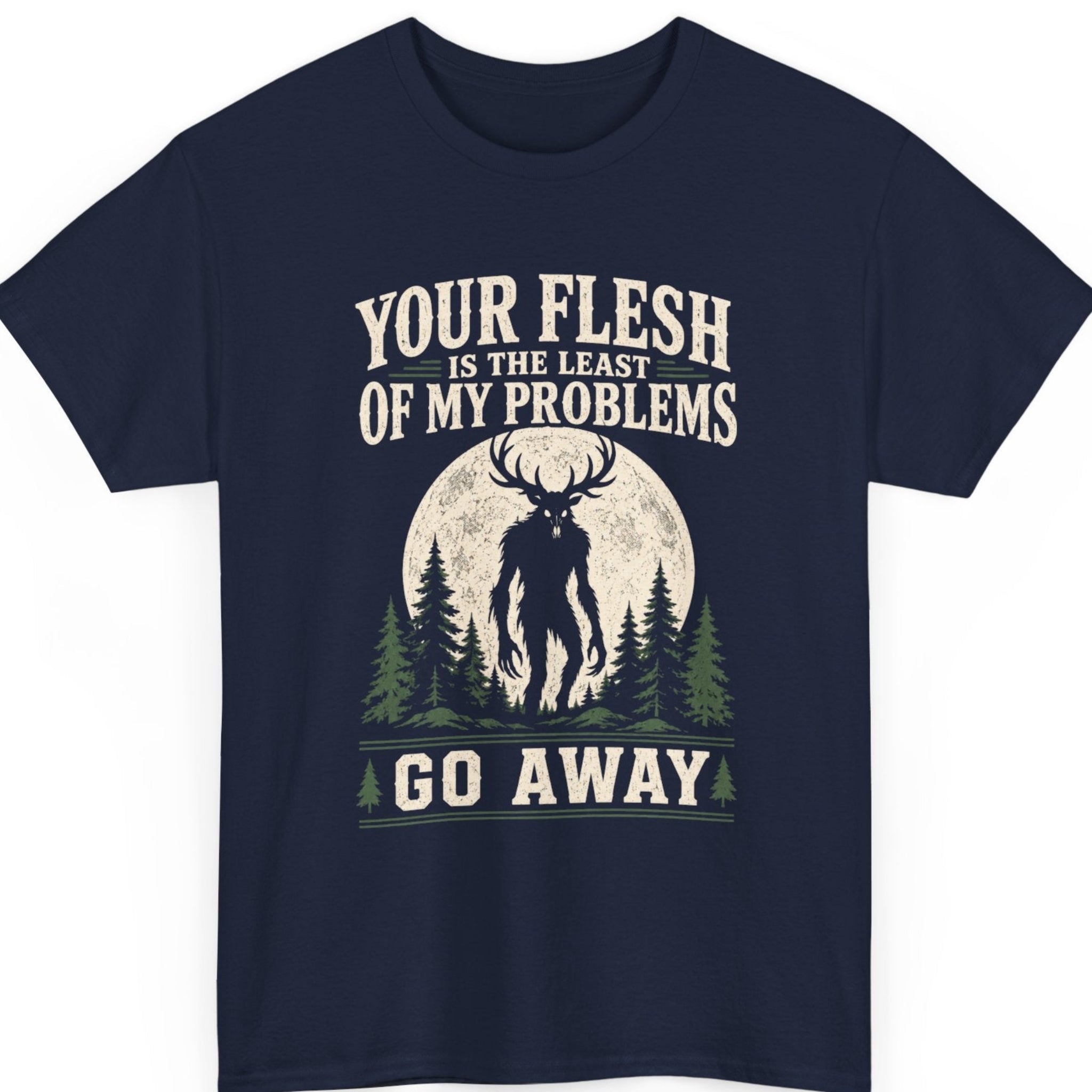Mayhem Haus cryptid t-shirt on a navy blue shirt featuring a haunting Wendigo silhouette with large antlers beneath a full moon, framed by pine trees and vintage typography reading "YOUR FLESH IS THE LEAST OF MY PROBLEMS GO AWAY."