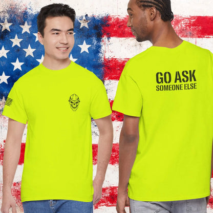 Two people wearing bright green t-shirts with text and a skull logo against an American flag background.