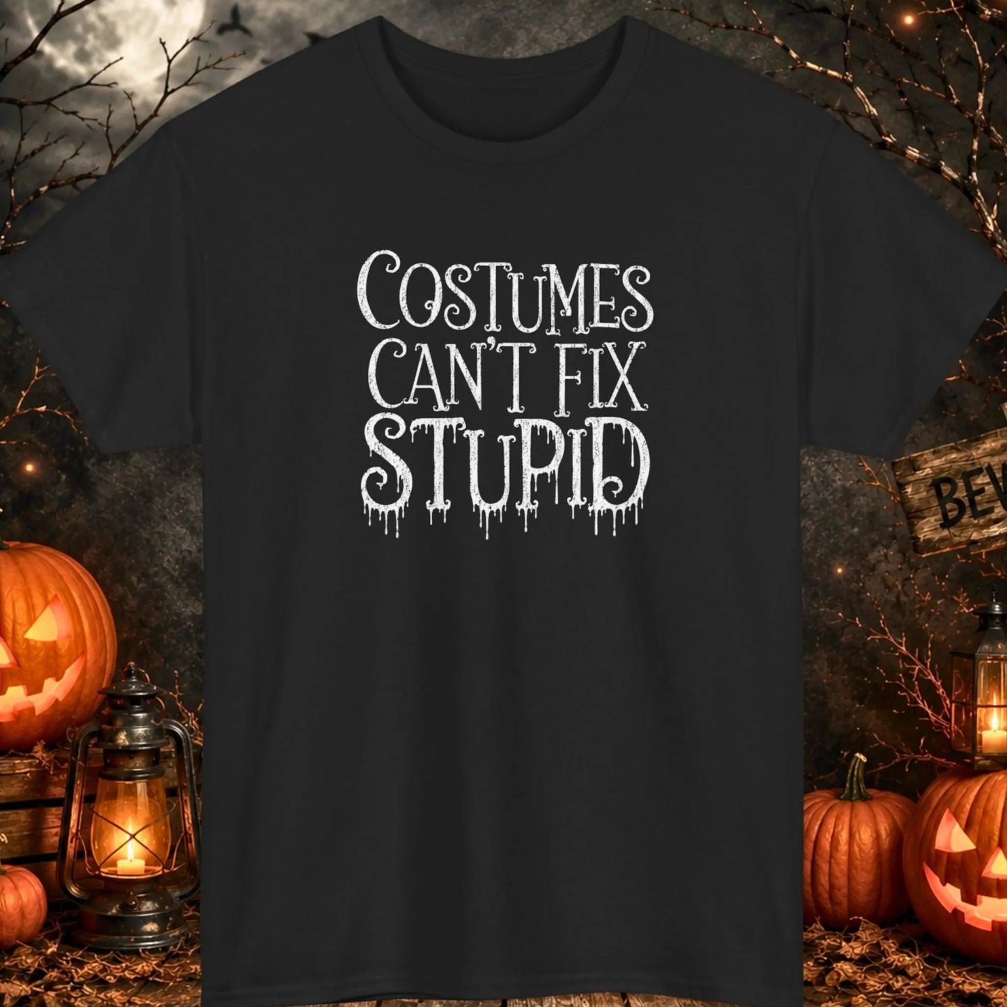 Funny Halloween typography t-shirt featuring distressed dripping horror lettering that reads "Costumes Can't Fix Stupid" in white print on a black shirt, perfect for Halloween parties, sarcastic humor fans, spooky season events, and dark humor lovers.