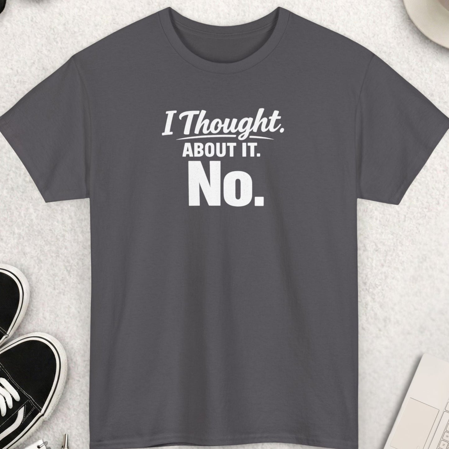 Gray t-shirt with 'I Thought About It. No.' text on a light gray surface with accessories.
