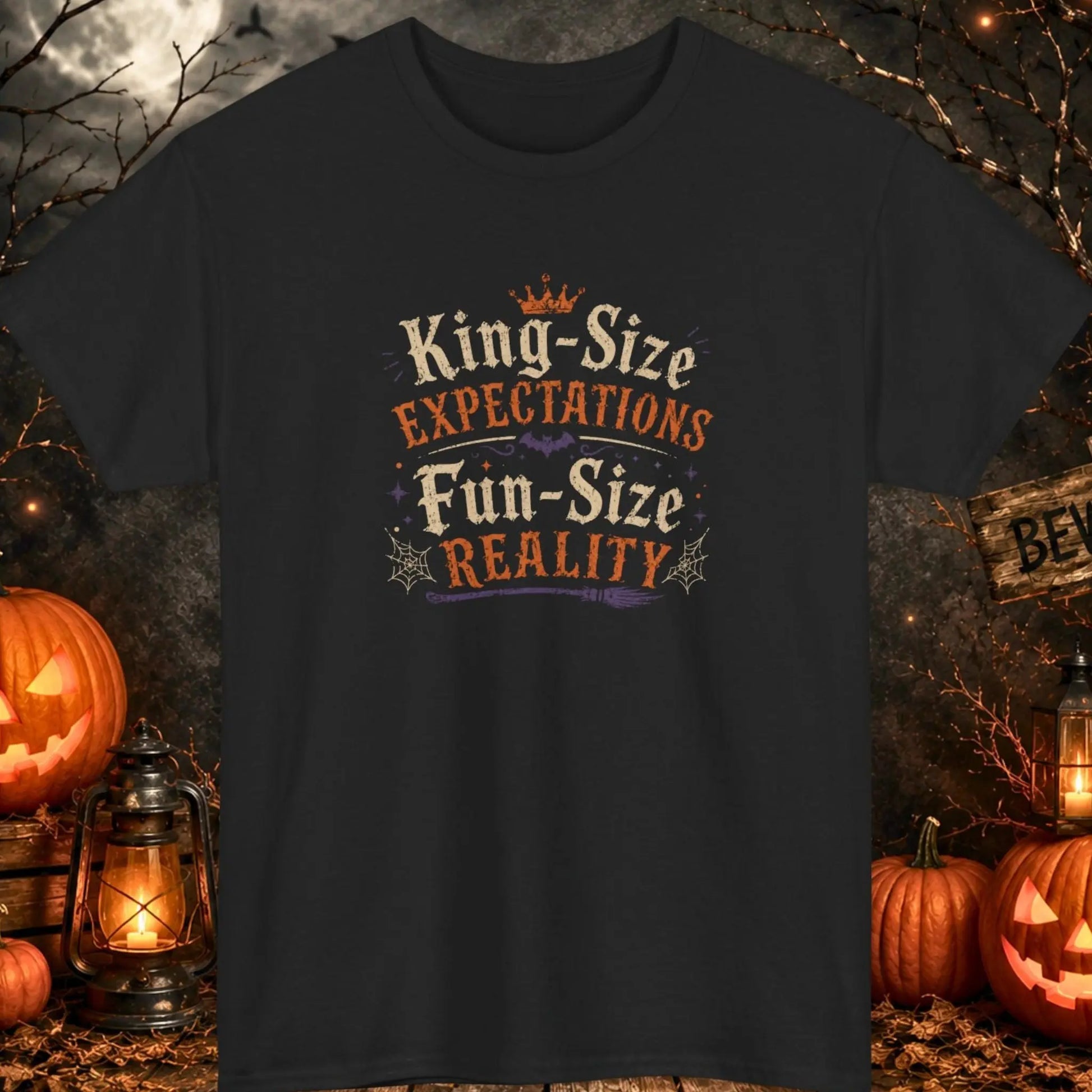 Funny Halloween graphic t-shirt featuring distressed vintage typography reading "King-Size Expectations Fun-Size Reality" with witch-themed accents, bats, spider webs, and spooky Halloween graphics printed on a black shirt, perfect for Halloween parties, candy lovers, and sarcastic humor fans.