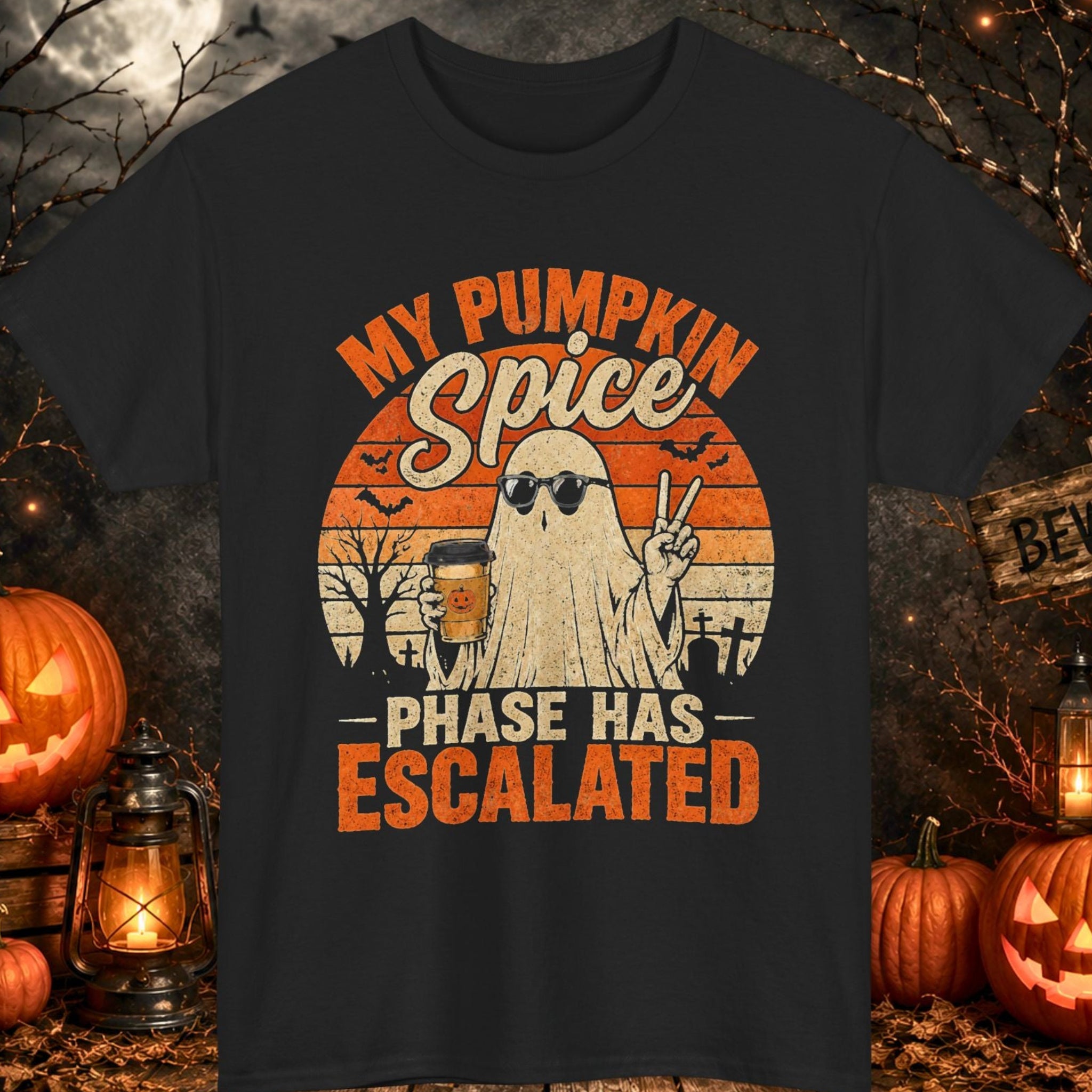 Mayhem Haus black Halloween T-shirt featuring a ghost wearing sunglasses while holding a pumpkin spice latte beneath the phrase "My Pumpkin Spice Phase Has Escalated." The distressed vintage design includes bats, a graveyard scene, a retro sunset background, and classic orange Halloween colors.