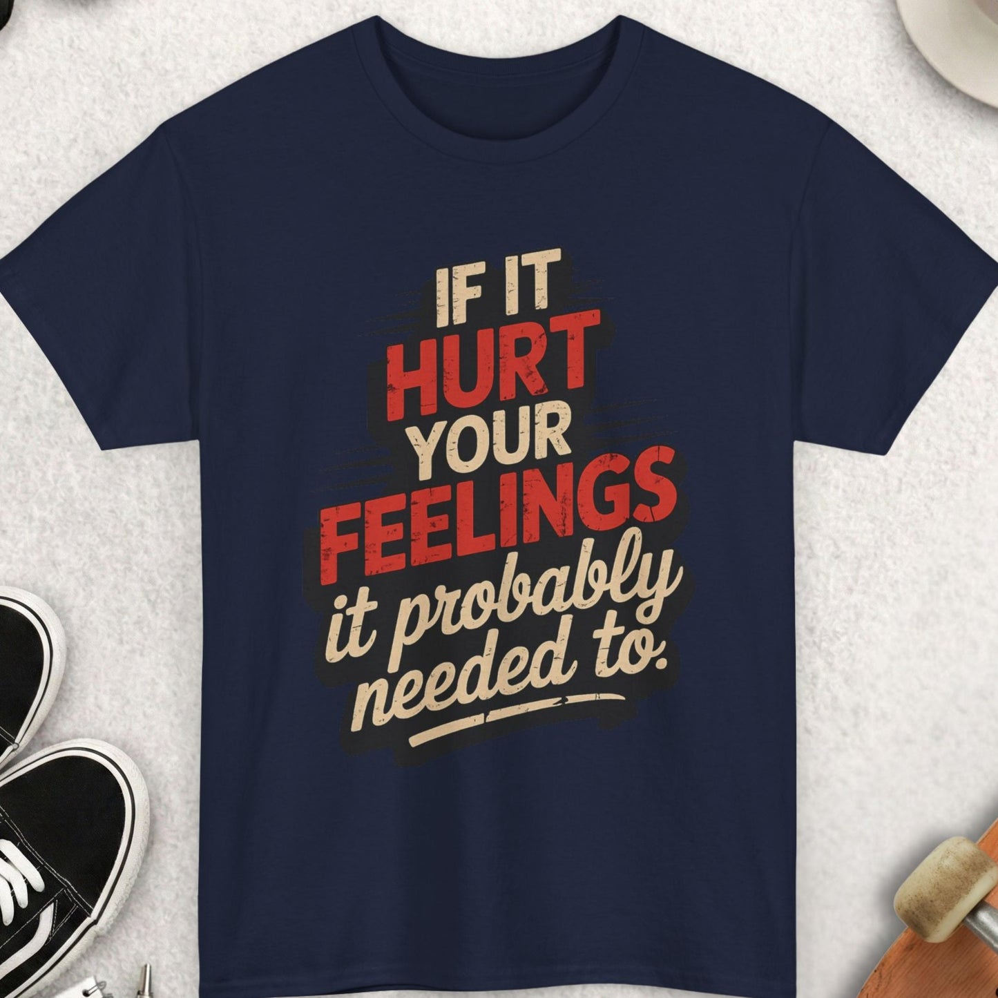 Navy blue t-shirt with humorous text design on a light gray surface with accessories.